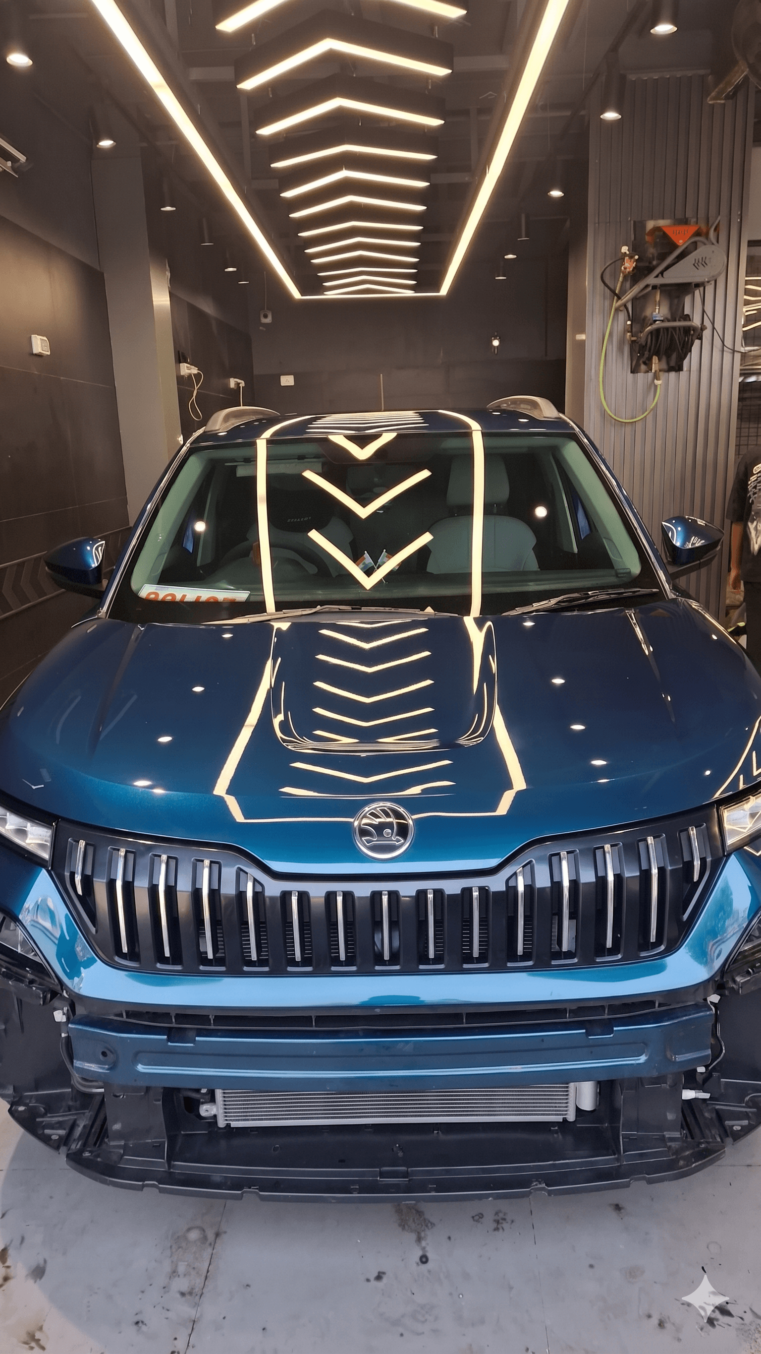 Blue car under studio lighting with a glossy front-end finish