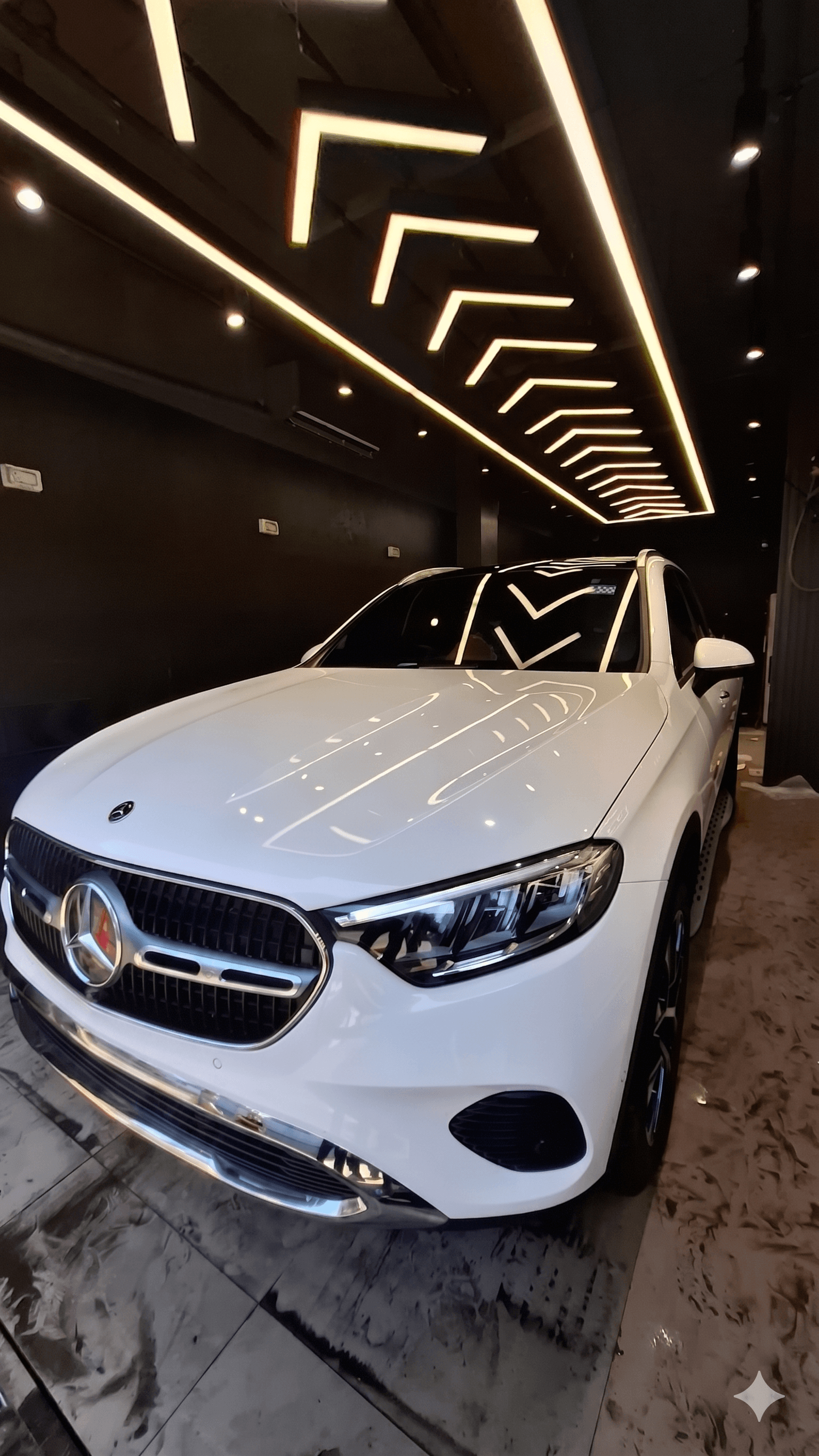 White Mercedes positioned inside the Shine My Ride studio bay