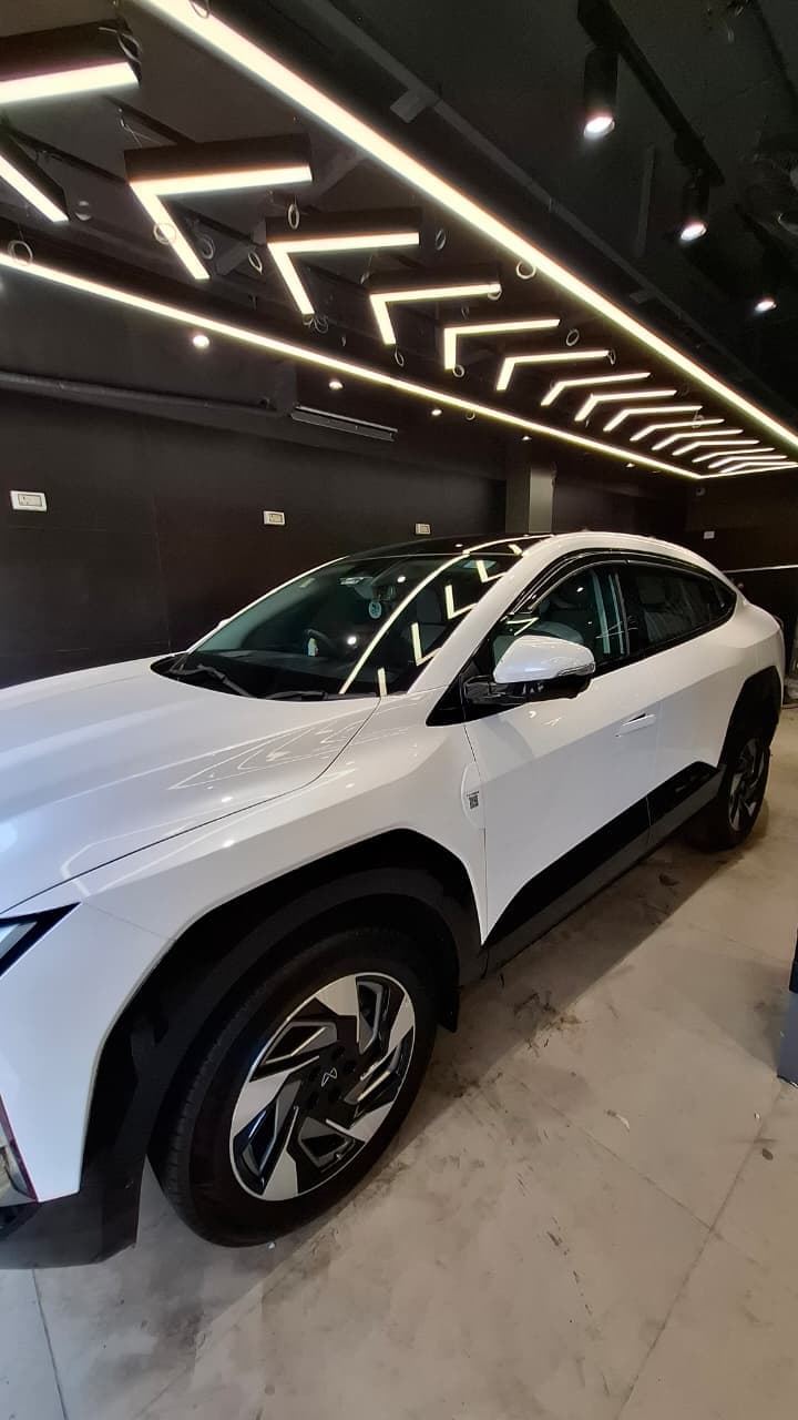 White electric vehicle photographed from the side inside the studio